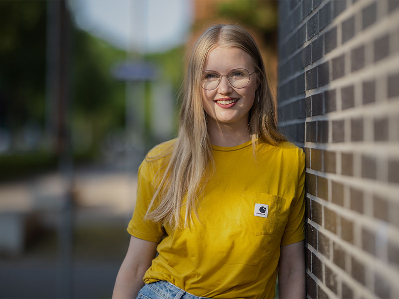 Person in gelbem T-Shirt draussen