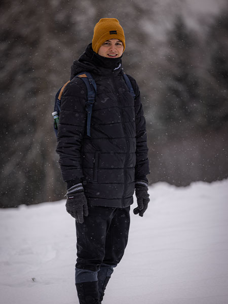 Eine Person mit warmen Kleidern im Schnee